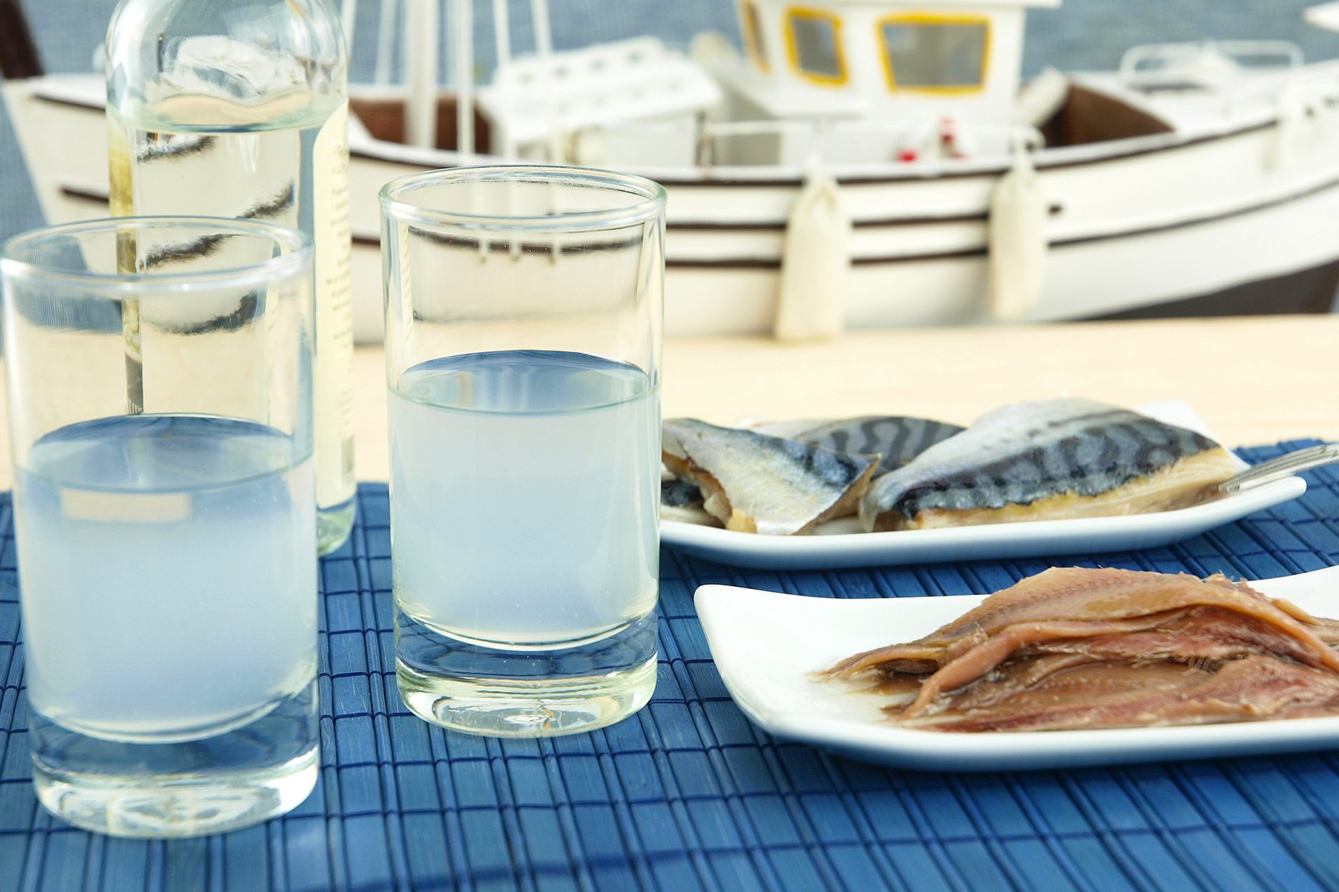 greckie ouzo podawane do ryb, na świeżym powietrzu w marinie z łódkami