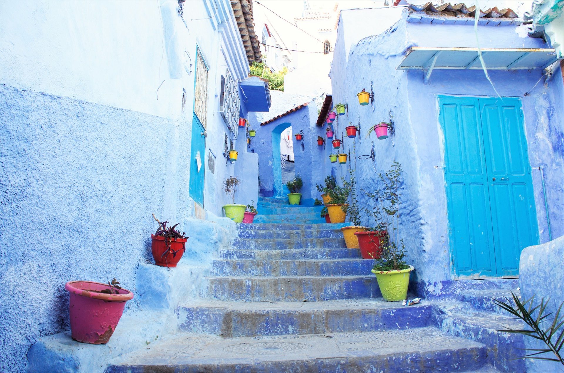 błekitne schody i kolorowe donice w medynie w Szafszawan w Maroku
