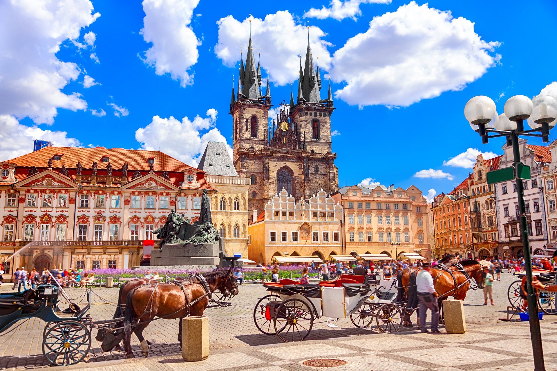 Bryczki czekające na turystów na Starum Miaeście w Pradze w tle kolorowe kamienice i kościół św. Mikołaja
