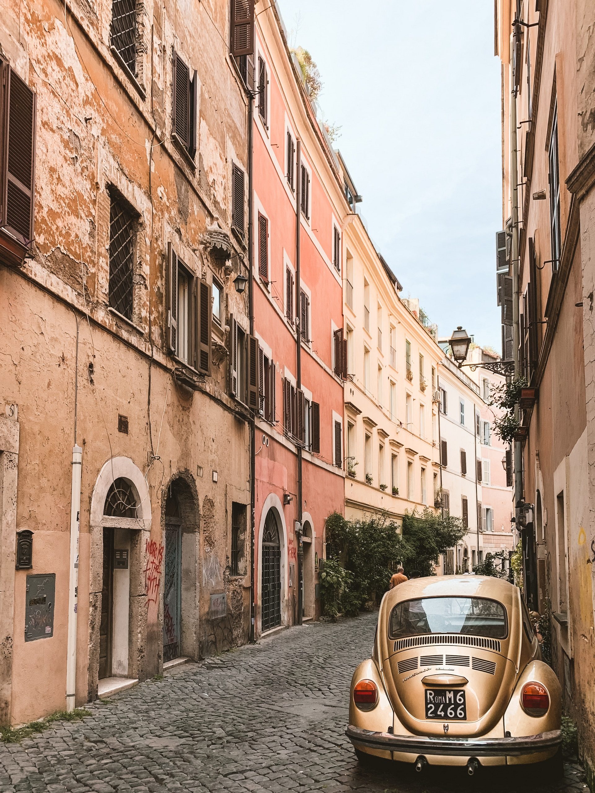 Stary samochód Garbus w ciasnej romantycznej uliczce Zatybrza w Rzymie