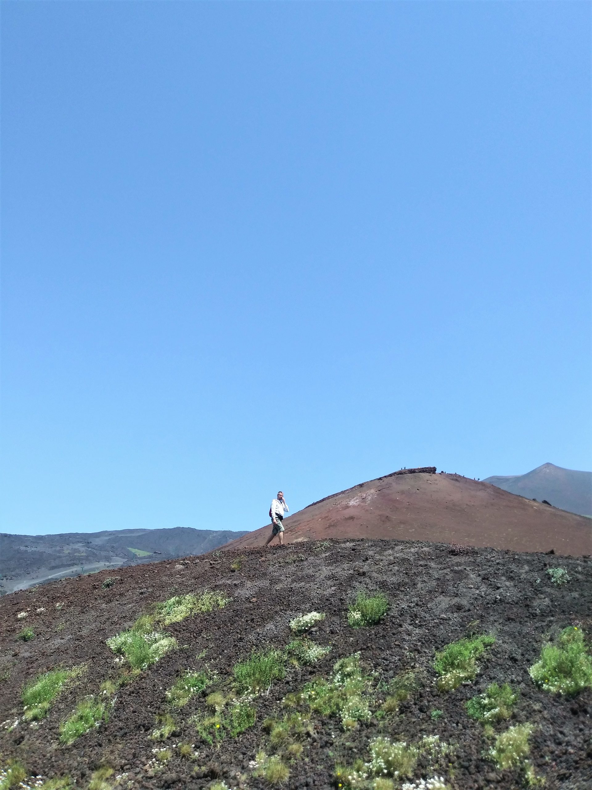 człoweik spaceruje po mneijszym kraterze Silvestre na wulkanie Etna we Włoszech na Sycylii