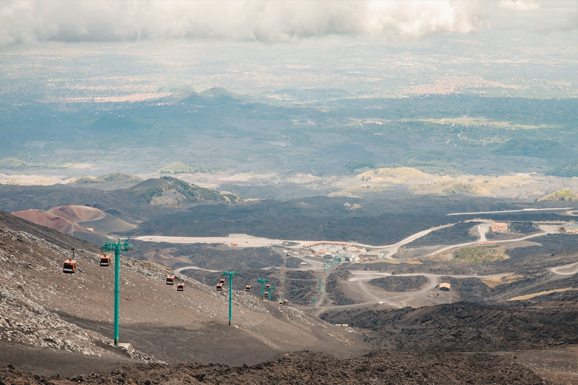 Widok spod górnego krateru wulkanu Etna, widok na czarne skały i kolejkę linową