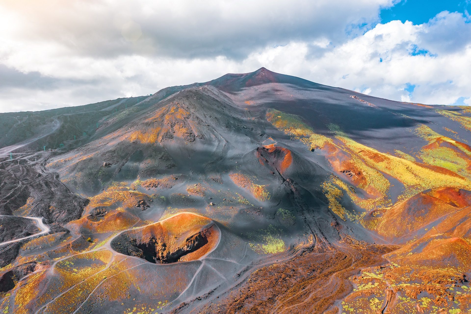Wspaniały widok na różnokolorowey bazalt i delikatnie przebijającą się zieleń roślinności na wulkanie Etna na Sycylii